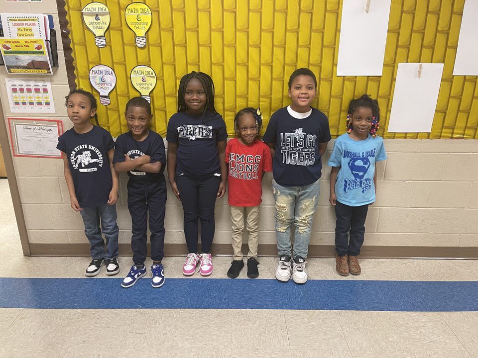 A group of children standing in a rowAI-generated content may be incorrect.